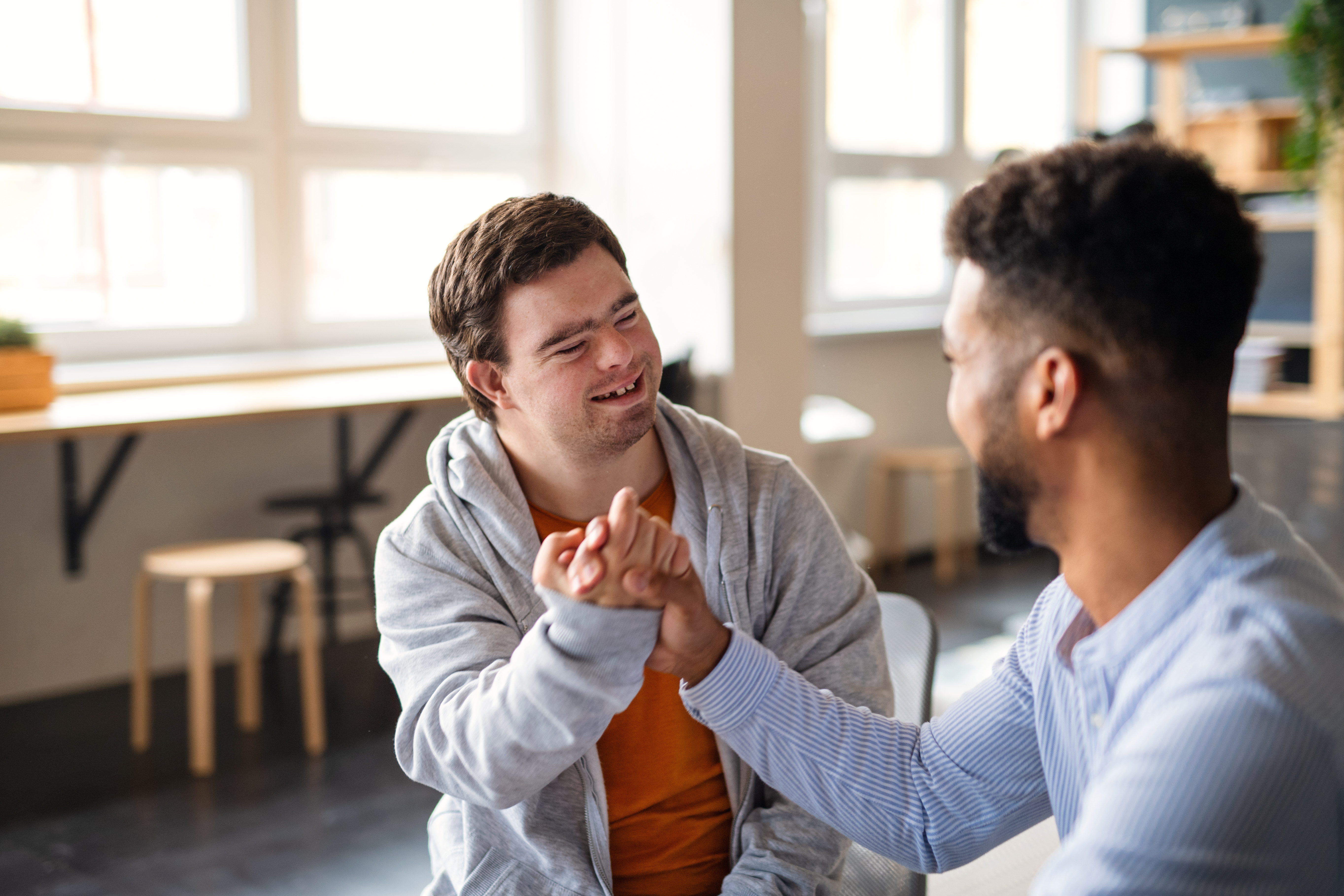 Student with Down Syndrome clapping hands with a fellow student