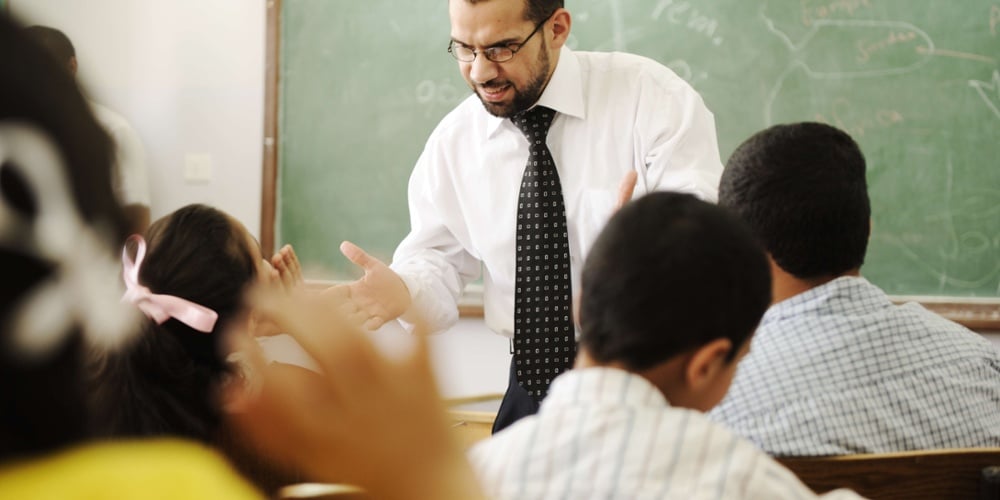 a teacher trying to quiet a noisy classroom