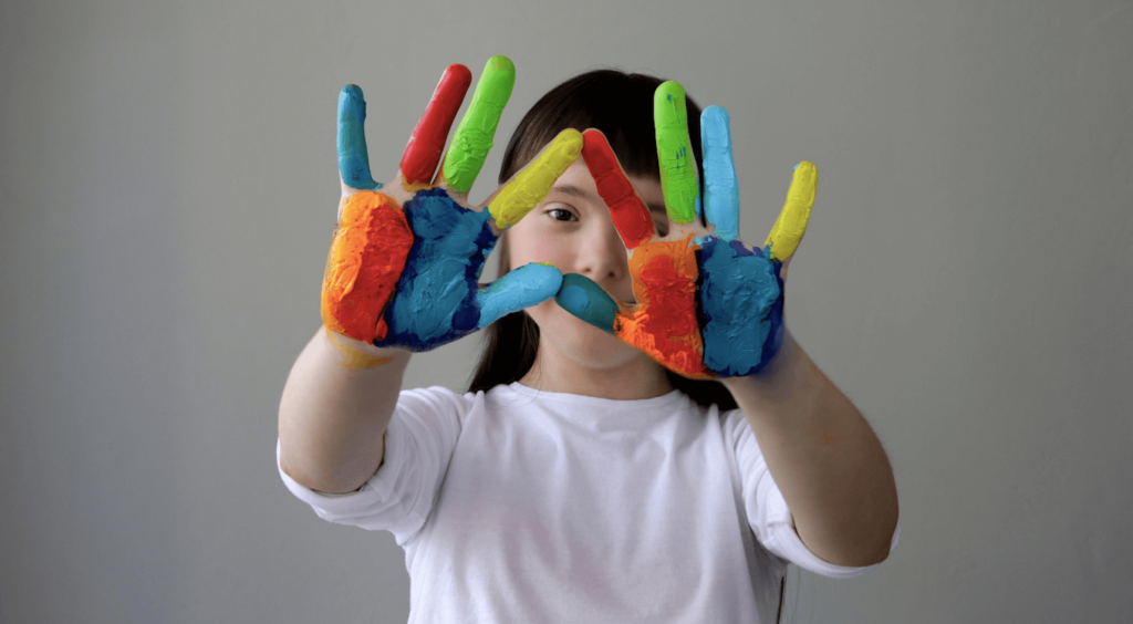 student with rainbow painted hands