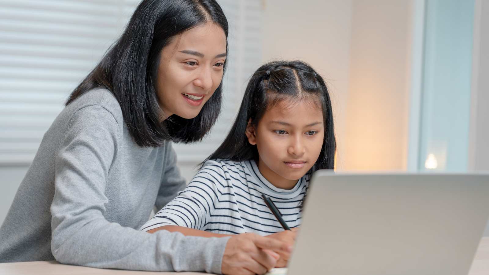 parent and student looking at student progress updates on the computer 